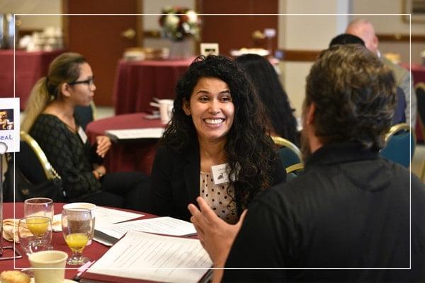 Man and woman speaking at an event table